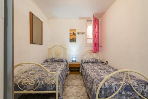 um quarto com 2 camas e uma janela em Villa Gianna - Appartamento Toscano em Quartu SantʼElena