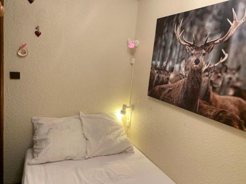 a bedroom with a painting of a deer on the wall at Studio Les Saisies, 1 pièce, 4 personnes - FR-1-293-165 in Les Saisies