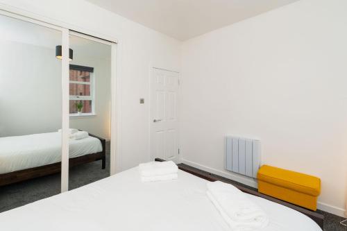 een slaapkamer met 2 bedden en een spiegel bij Bissets Bond in Dundee