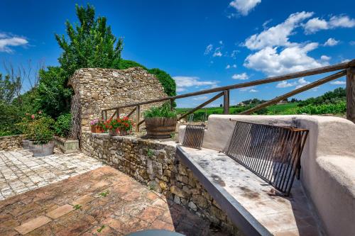 a bench on a stone wall with potted plants at Villa S.Andrea in San Casciano in Val di Pesa