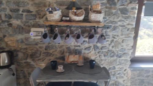 a room with a stone wall with a table and baskets at La pietra di Sersa in Quaratica