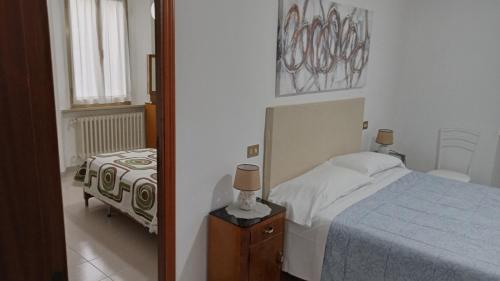 sypialnia z łóżkiem i stołem z lampką w obiekcie Il piccolo casale 1950 w mieście Fabriano