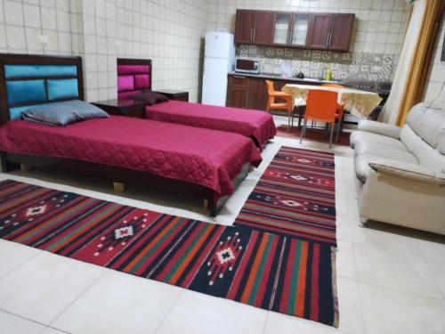 a living room with two beds and a kitchen at Greek Villa in Jerash