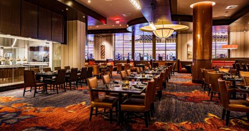 um restaurante com mesas e cadeiras e um bar em Southland Casino Hotel em West Memphis