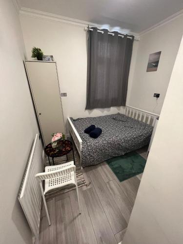 a small bedroom with a bed and a mirror at Lovely apartment close to Acton central station in London