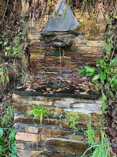an old stone wall with a rock on top of it at A Casa da Fonte in Santa Eulalia de Oscos