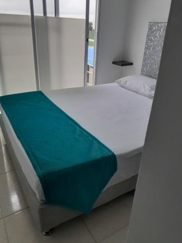Un dormitorio con una cama con una manta verde. en construcciones Guaduales del café, en Montenegro