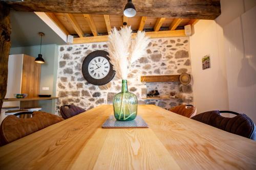 a wooden table with a vase on top of it at Lodge ou Gîte de caractére avec jaccuzi spa piscine in Argelès-Gazost