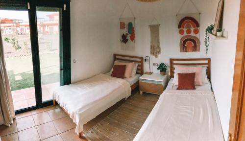 two beds in a room with a window at Casa Encanto in Lajares
