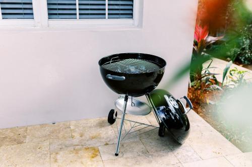a barbecue grill sitting next to a wall at Casa Cordova Apartments By Lowkl in Fort Lauderdale
