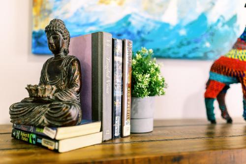 Um monte de livros numa prateleira com uma estátua. em Casa Cordova By Lowkl em Fort Lauderdale