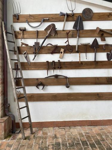 a wall with a bunch of tools hanging on a wall at Casa Civetta in Castel Colonna