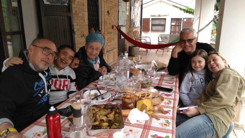 a group of people sitting around a table with food at Casa Civetta in Castel Colonna