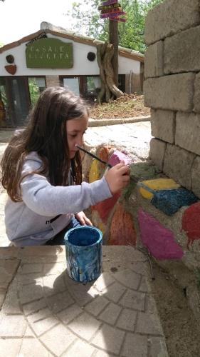 a young girl playing with paint on a wall at Casa Civetta in Castel Colonna