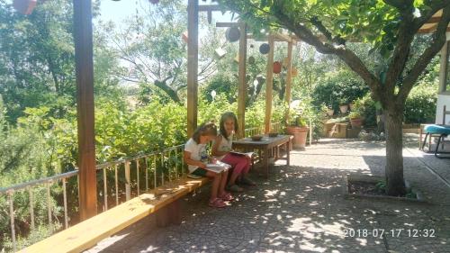 a woman and a child sitting on a bench at Casa Civetta in Castel Colonna