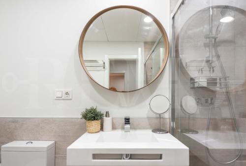 łazienka z białą umywalką i lustrem w obiekcie Lovely Boho apartment with parking - Historic Center by REMS w Maladze