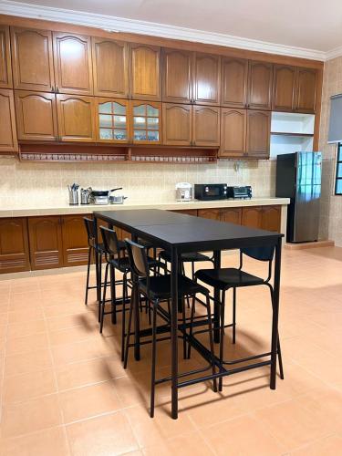 a kitchen with a black table and chairs at Villa Ruby - with private swimming pool in Kota Bharu