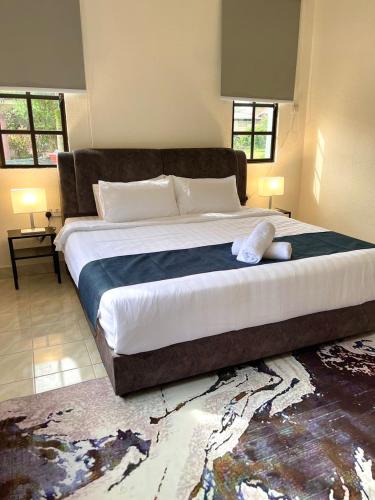a bedroom with a large bed with a blue blanket at Villa Ruby - with private swimming pool in Kota Bharu