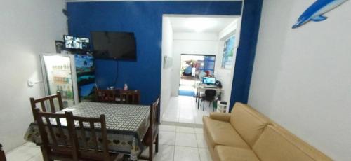 a living room with a table and a blue wall at Paradise Hostel Ilha Grande in Abraão