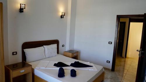 a bedroom with a white bed with two robes on it at Swiss Royal DAHAB in Dahab