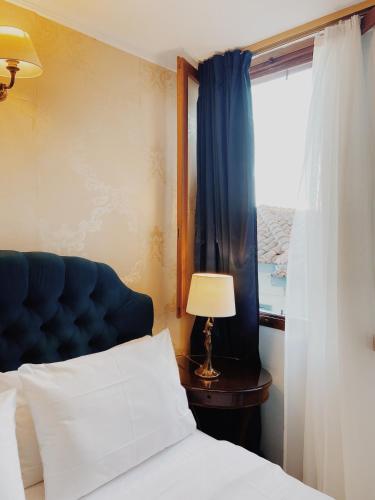 a bedroom with a bed with a blue headboard and a window at Five Seasons in Nafplio