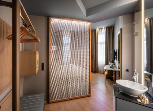 een badkamer met een douche en een witte wastafel bij 987 Design Prague Hotel in Praag