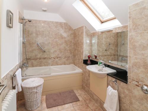 y baño con bañera y lavamanos. en Ring of Kerry Golf Club Cottage en Kenmare