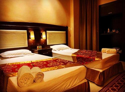 two beds in a hotel room with towels on them at فندق بردى in Qaryat al Bulush