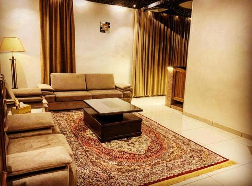 a living room with a couch and a coffee table at BARADA Hotel- فندق بردى in Qaryat al Bulush