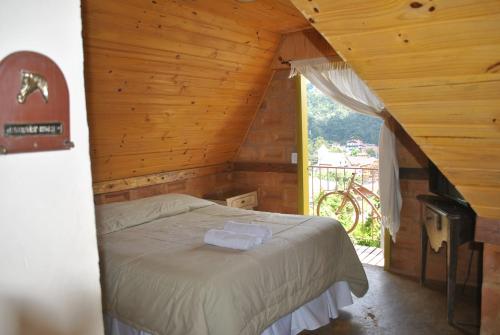 a bedroom with a bed in a wooden cabin at Hostel da Montanha in Campos do Jordão