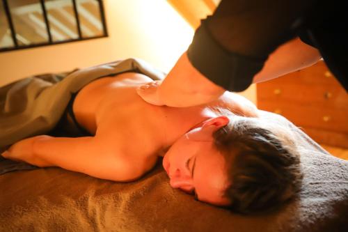 a man is giving a naked child a massage at Lodge ou Gîte de caractére avec jaccuzi spa piscine in Argelès-Gazost