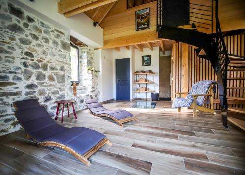 a living room with wooden floors and a stone wall at Lodge ou Gîte de caractére avec jaccuzi spa piscine in Argelès-Gazost