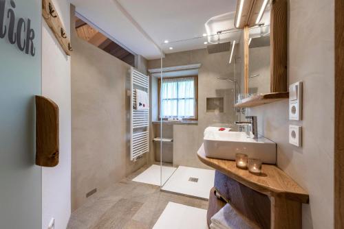 a bathroom with a sink and a shower at Bergblick App Lärche in Funes