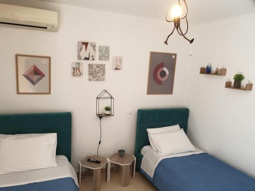 a bedroom with two beds and a lamp on the wall at Δροσιά in Nafplio