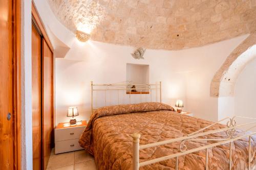 sypialnia z łóżkiem w białym pokoju w obiekcie Trulli da Tommaso - Martina Franca w mieście Martina Franca