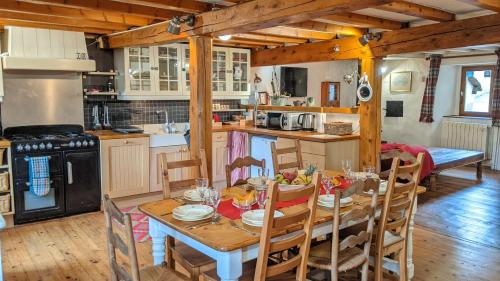 レ・ザングルにあるLa Ferme des Astresのキッチン(木製テーブル、椅子付)、ダイニングルーム