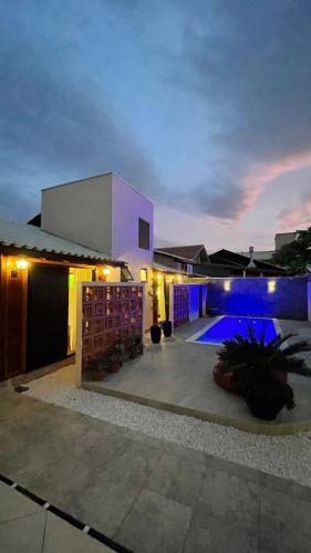 una casa con piscina por la noche en Pousada Casa Mariscal en Bombinhas