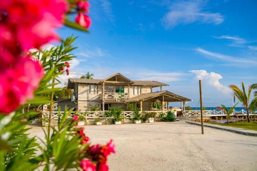 a house on the beach with flowers in the foreground at Quinta del Mar Sunset in Isla Mucura