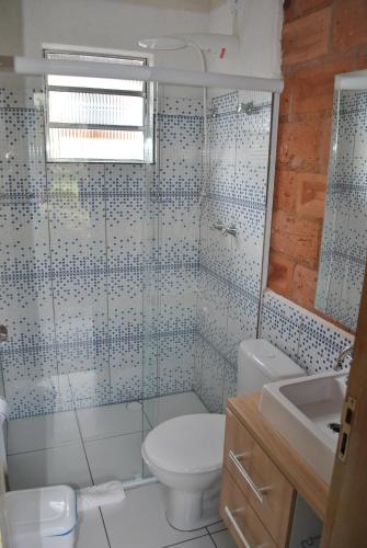 a bathroom with a toilet and a shower and a sink at Hostel da Montanha in Campos do Jordão