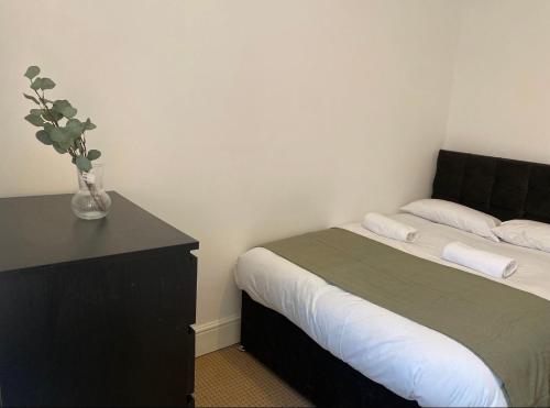 a bedroom with a bed and a vase of flowers on a table at Alexander Apartments Gateshead North in Gateshead