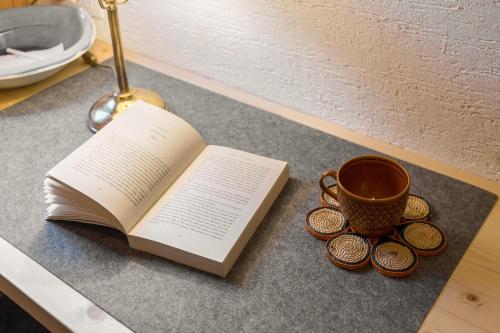 a book and a cup of coffee on a table at Chalet Trzinka - Triglav National Park in Goreljek