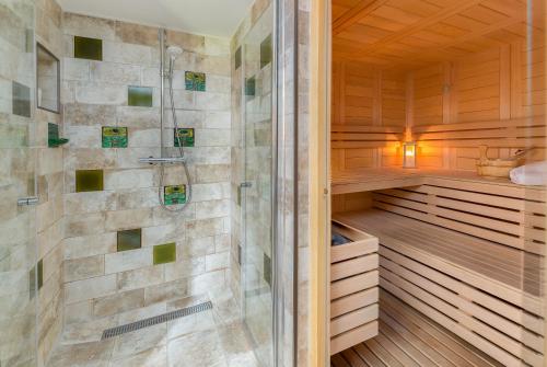a sauna with a walk in shower and a shower at Chalet Trzinka - Triglav National Park in Goreljek