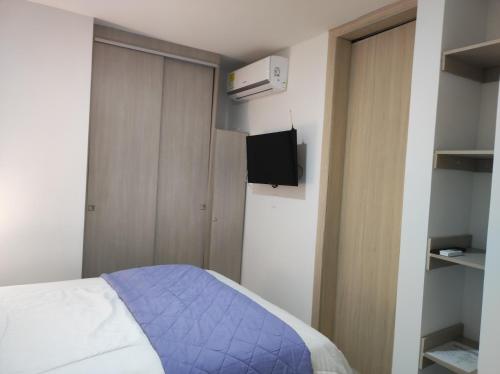 1 dormitorio pequeño con 1 cama y TV en Comfort Rooms Barranquilla Zafiro Deux, en Barranquilla