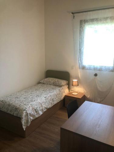 Schlafzimmer mit einem Bett, einem Fenster und einem Tisch in der Unterkunft al poset in Paderno del Grappa