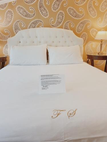 a white bed with white pillows in a bedroom at Five Seasons in Nafplio