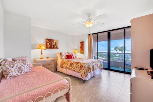 a bedroom with two beds and a balcony at Crescent Beach Club I 5A in Clearwater Beach