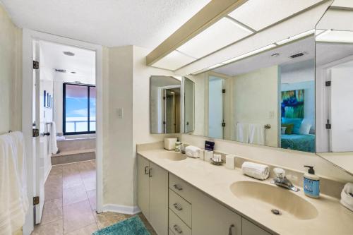a bathroom with two sinks and a large mirror at Crescent Beach Club I 5A in Clearwater Beach