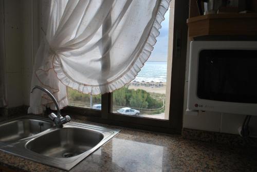 a kitchen sink and a window with a view of the ocean at Playamar 231 in Alcossebre