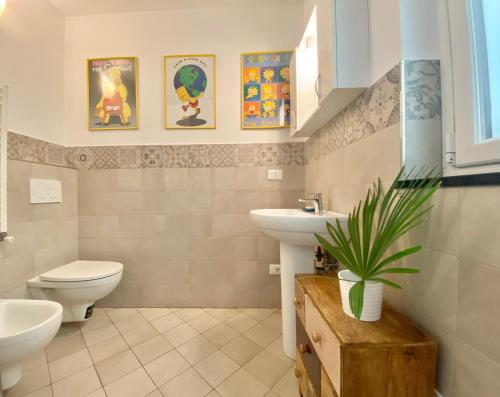 een badkamer met twee wastafels en een toilet en een plant bij CASAVIVA - Bilo with SeaView and parking in Camogli in Camogli