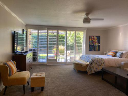 a bedroom with a bed and a tv and a chair at Large Creekside Studio at Shadow Mountain Resort and Club in Palm Desert
